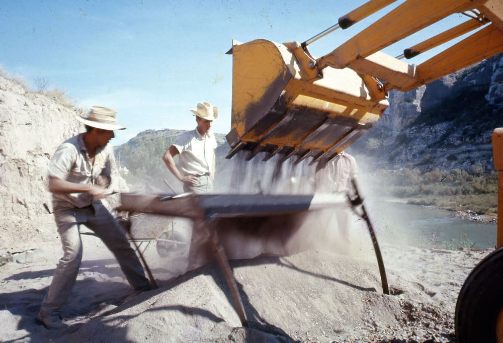 Dave Dibble watches as a member of his crew screens the dirt collected by the backhoe