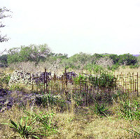 A wrought-iron fence is a distinctly German element in the otherwise rustic cemetery. The occupant of the grave is unknown. Photo by Susan Dial.