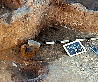 photo of collared hearth adjacent to possibly collapsed wall in House 1