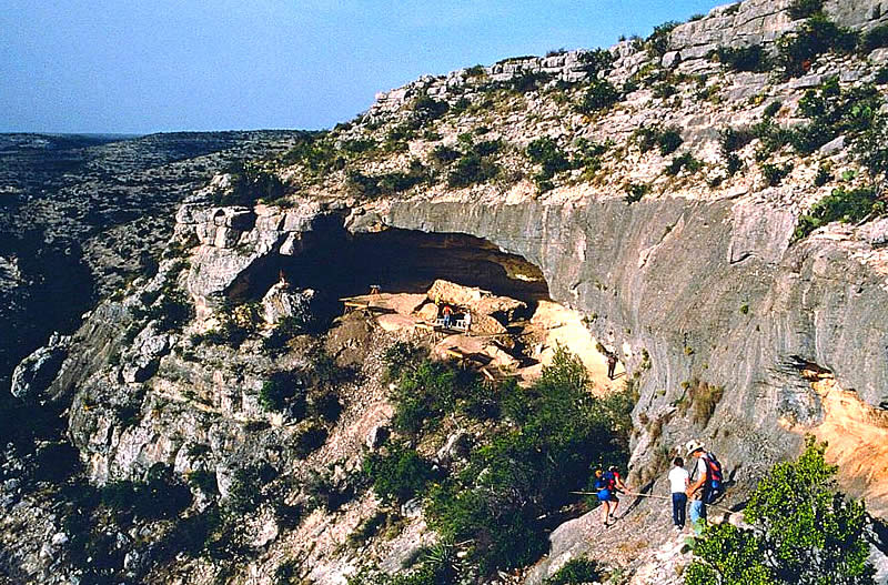 people walk to a rockshelter