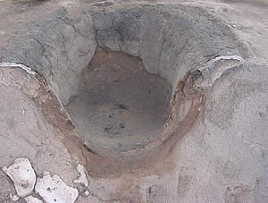 photograph of a cut in half concave hearth feature in the ground