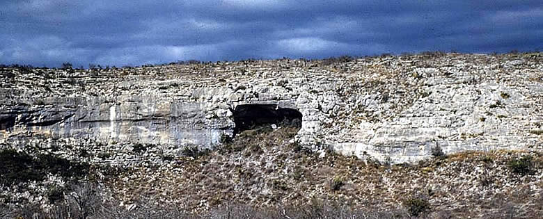 photograph of a long rockshelter entrance in a cliff face