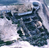 Aerial photograph of ruins of walled structures built with rocks, which is partially standing.