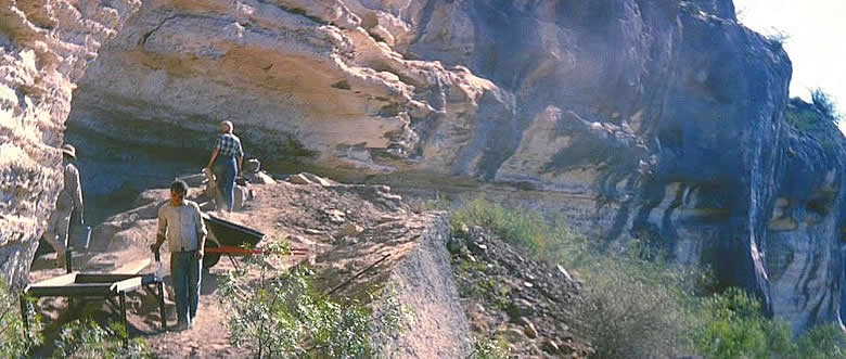 Excavations underway at Coontail Spin Cave in 1962. Access to this cave was extremely challenging because of its remote location. Archeologists reached it by descending a long, steep slope from the opposite canyon wall and then climbing up a narrow tortuous path to the cave. Photo from ANRA-NPS Archives at TARL.