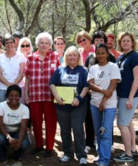 photo of members of the Manchaca/Onion Creek Historical Association (MOCHA) touring the site with archeologists. 