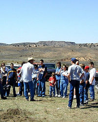 Photo of man talking to a group of people. 